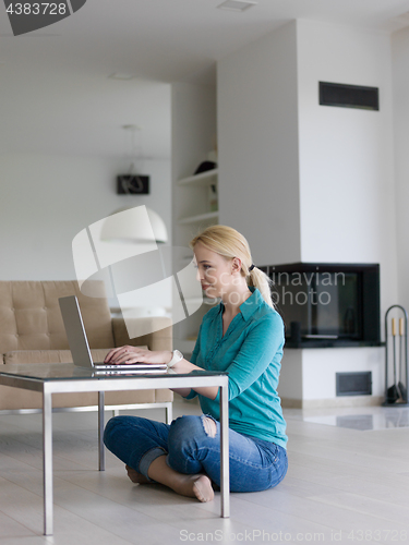 Image of young women using laptop computer on the floor