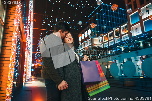 Image of The happy couple with shopping bags enjoying night at city background