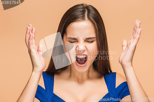 Image of Frustrated young woman screaming at studio
