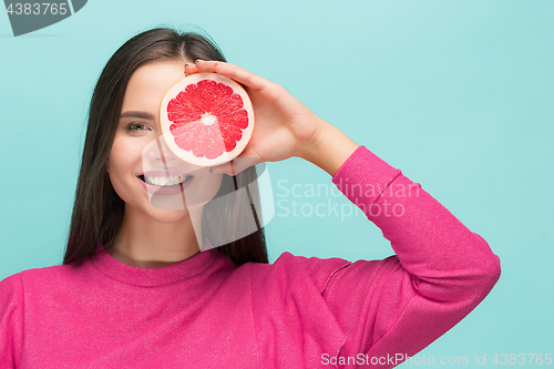 Image of Pretty woman with delicious grapefruit in her arms.