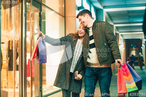 Image of The happy couple with shopping bags enjoying night at city background