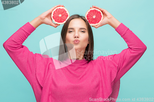 Image of Pretty woman with delicious grapefruit in her arms.