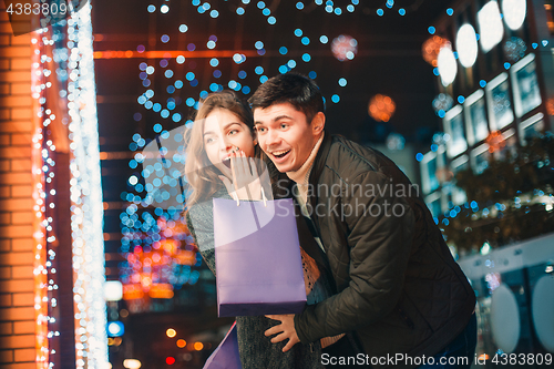 Image of The happy couple with shopping bags enjoying night at city background