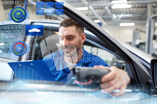 Image of mechanic man with diagnostic scanner at car shop