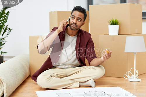 Image of man with blueprint and boxes moving to new home