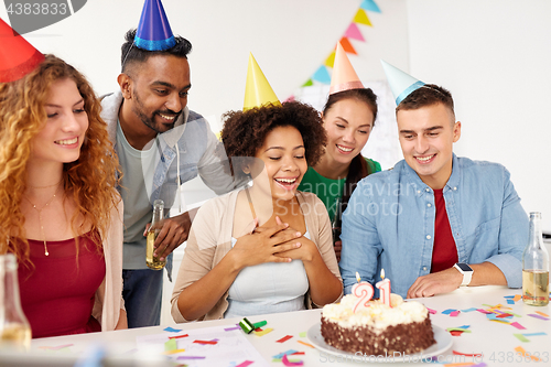 Image of team greeting colleague at office birthday party