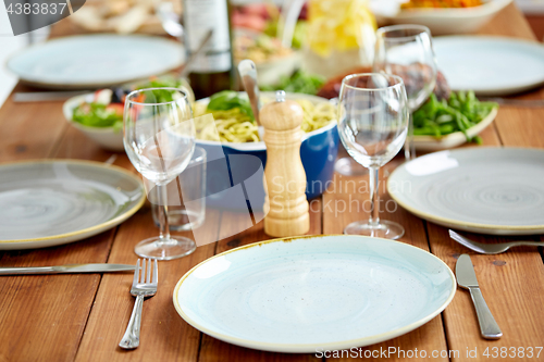 Image of table served with plates, wine glasses and food