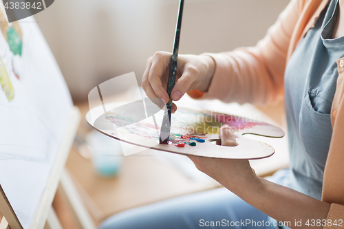 Image of artist with palette painting at art studio