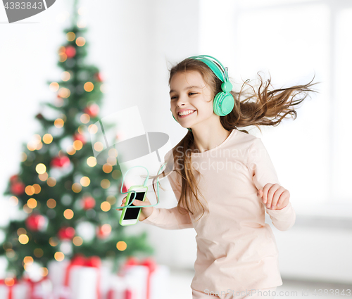 Image of girl with smartphone and headphones at christmas