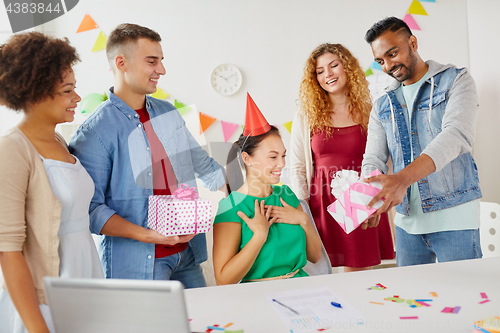 Image of team greeting colleague at office birthday party