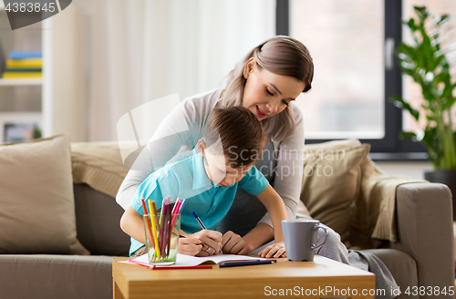 Image of mother and son with workbook at home