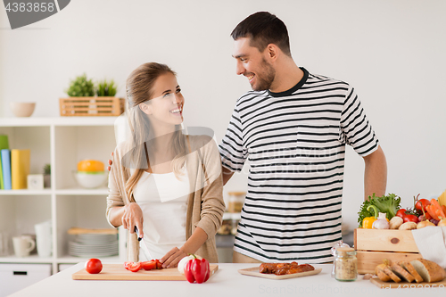 Image of happy couple cooking food at home kitchen