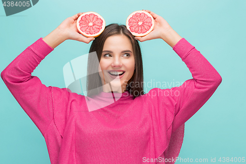 Image of Pretty woman with delicious grapefruit in her arms.