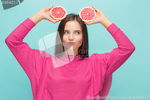 Image of Pretty woman with delicious grapefruit in her arms.