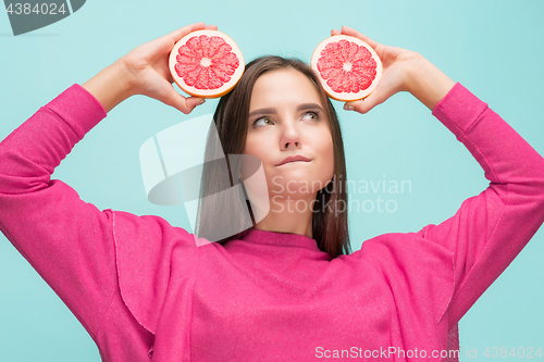 Image of Pretty woman with delicious grapefruit in her arms.