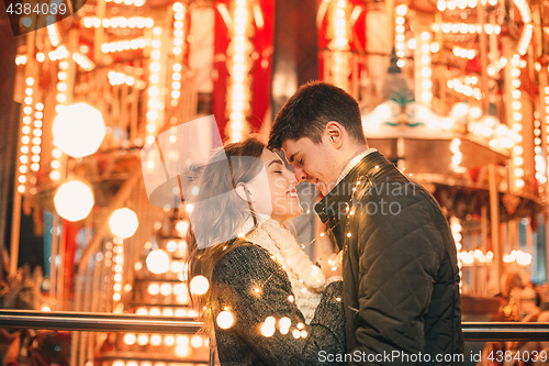 Image of Young couple kissing and hugging outdoor in night street at christmas time