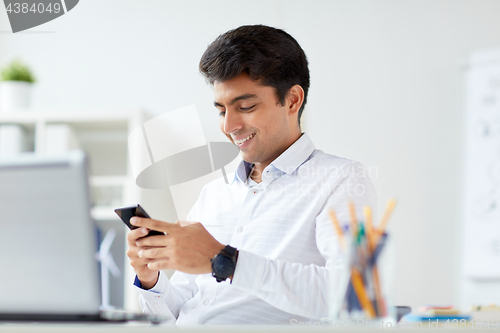 Image of happy businessman with smartphone at office