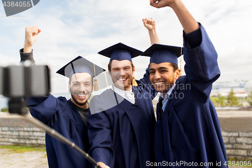 Image of happy male students or graduates taking selfie