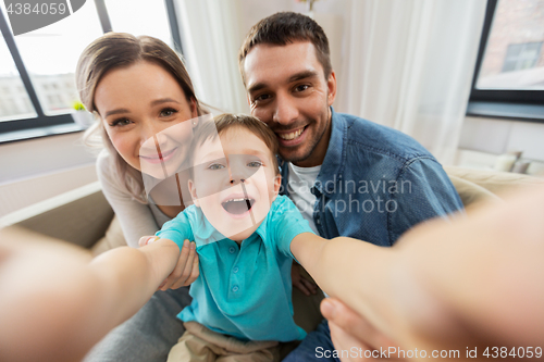 Image of happy family taking selfie at home