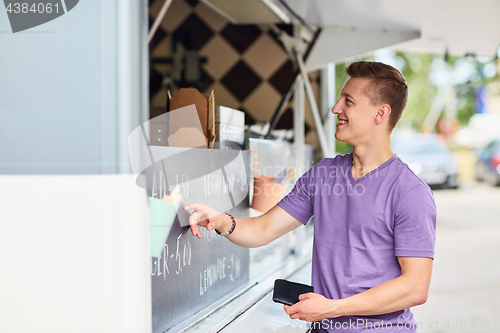 Image of male customer with wallet at food truck