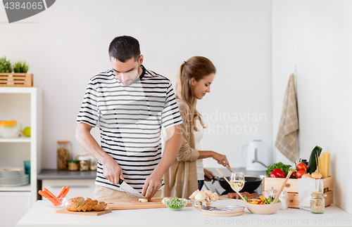 Image of couple cooking food at home kitchen