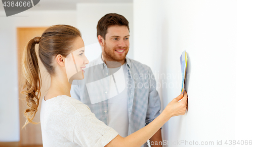 Image of happy couple with color samples at new home