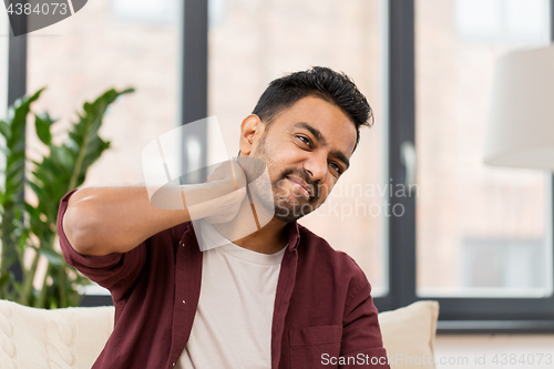 Image of unhappy man suffering from neck pain at home