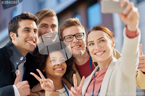 Image of business team with conference badges taking selfie