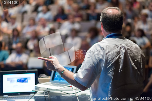 Image of Public speaker giving talk at Business Event.