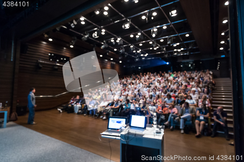 Image of Business speaker giving a talk in conference hall.