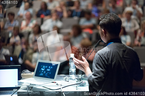 Image of Public speaker giving talk at Business Event.