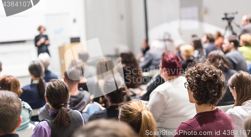 Image of Woman giving presentation in lecture hall at university.