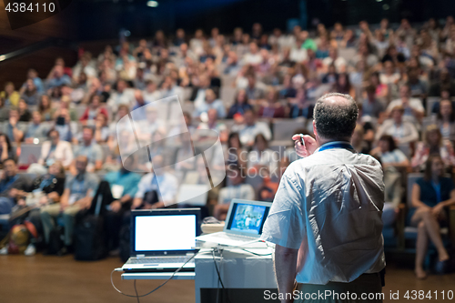 Image of Public speaker giving talk at Business Event.