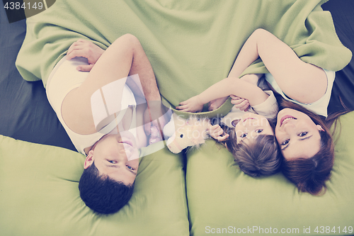 Image of happy family relaxing in bed