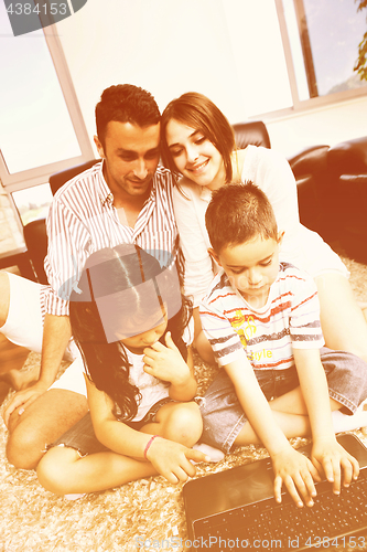 Image of happy young family have fun and working on laptop at home