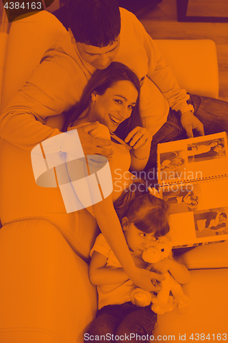Image of happy family looking photos at home