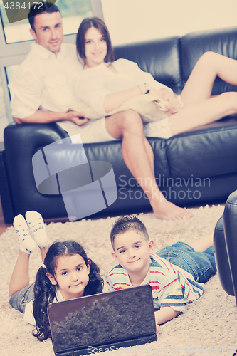 Image of happy young family have fun and working on laptop at home