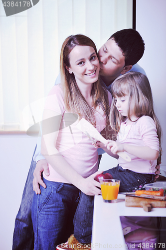 Image of happy young family in kitchen