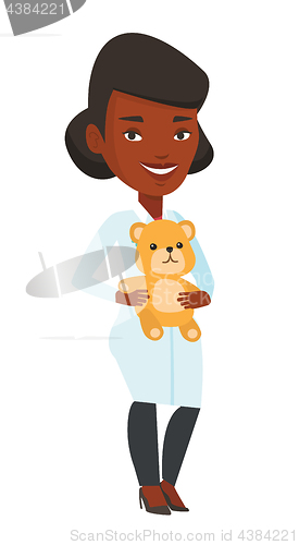 Image of Pediatrician doctor holding teddy bear.