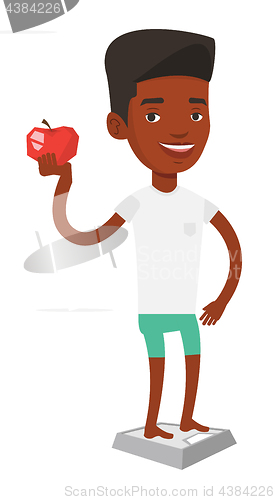 Image of Man standing on scale and holding apple in hand.