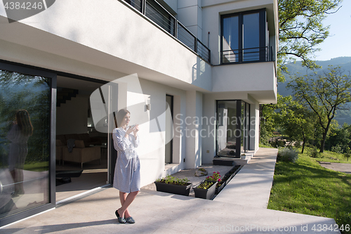 Image of woman in a bathrobe enjoying morning coffee