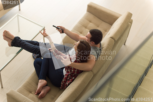 Image of Young couple on the sofa watching television