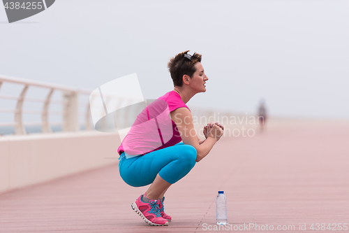 Image of woman stretching and warming up on the promenade