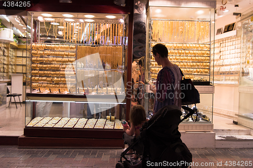 Image of mother with  little girl in a stroller in front of  jewelry shop