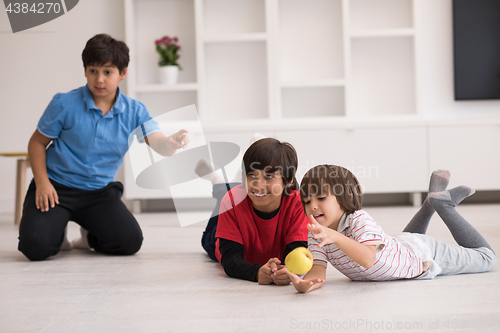 Image of boys having fun with an apple on the floor