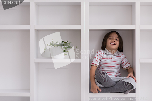 Image of young boy posing on a shelf