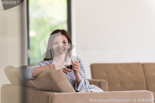 Image of young woman in a bathrobe enjoying morning coffee