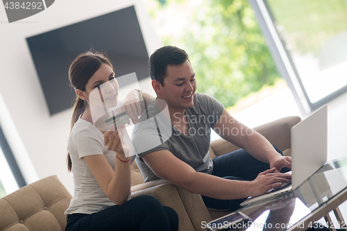 Image of happy young couple buying online