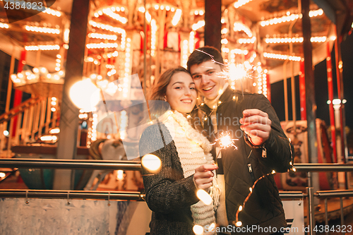 Image of Young couple kissing and hugging outdoor in night street at christmas time