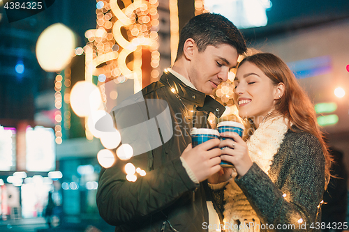 Image of Young couple kissing and hugging outdoor in night street at christmas time